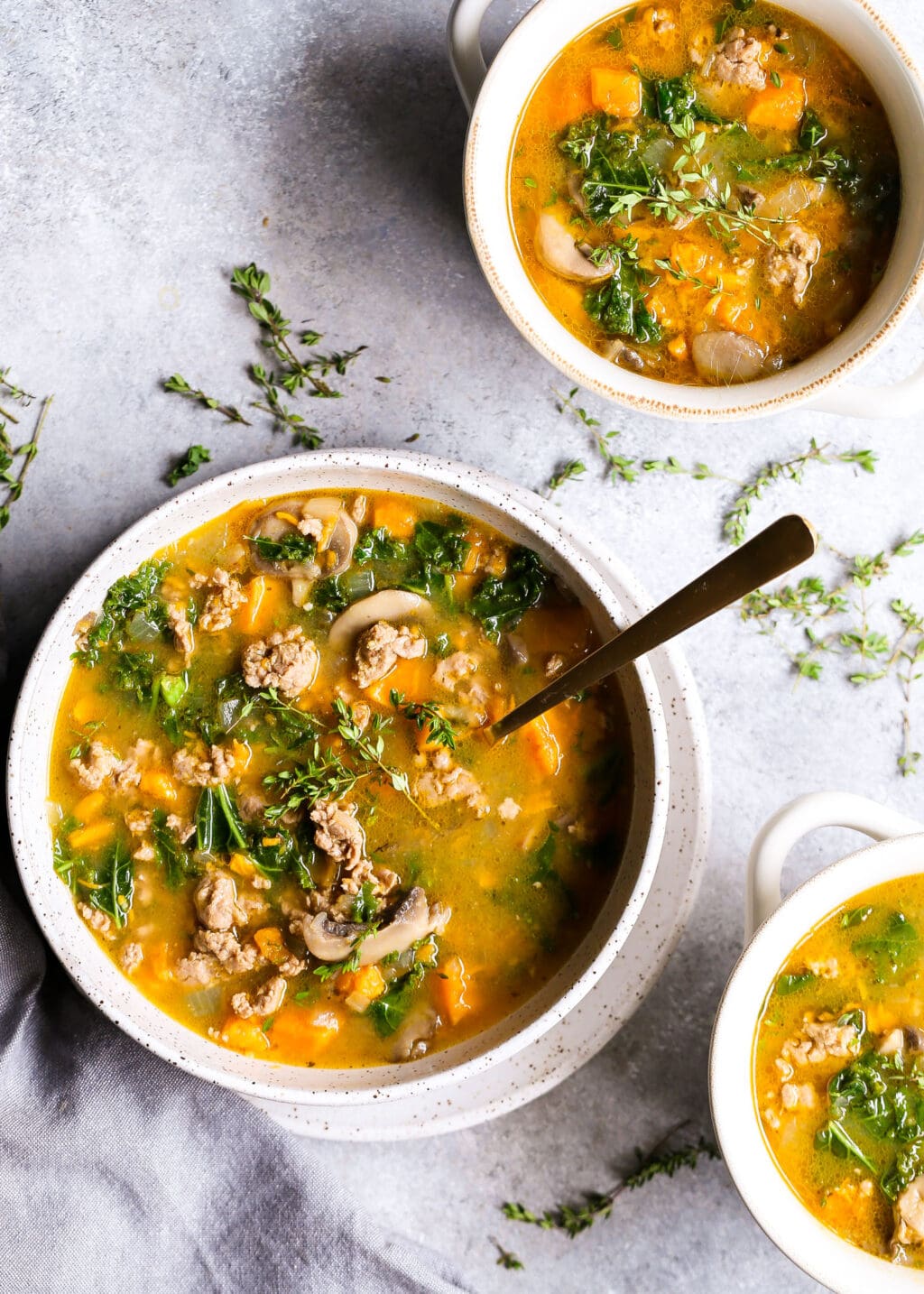 A delicious looking bowl of soup made from pork broth with kale, mushrooms, carrots, rice and pork breakfast sausage