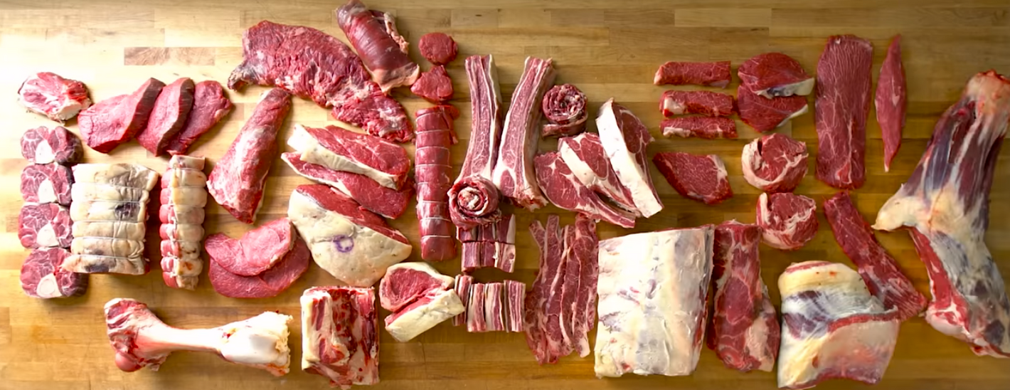 Butchered grass fed beef on a wooden butcher table.