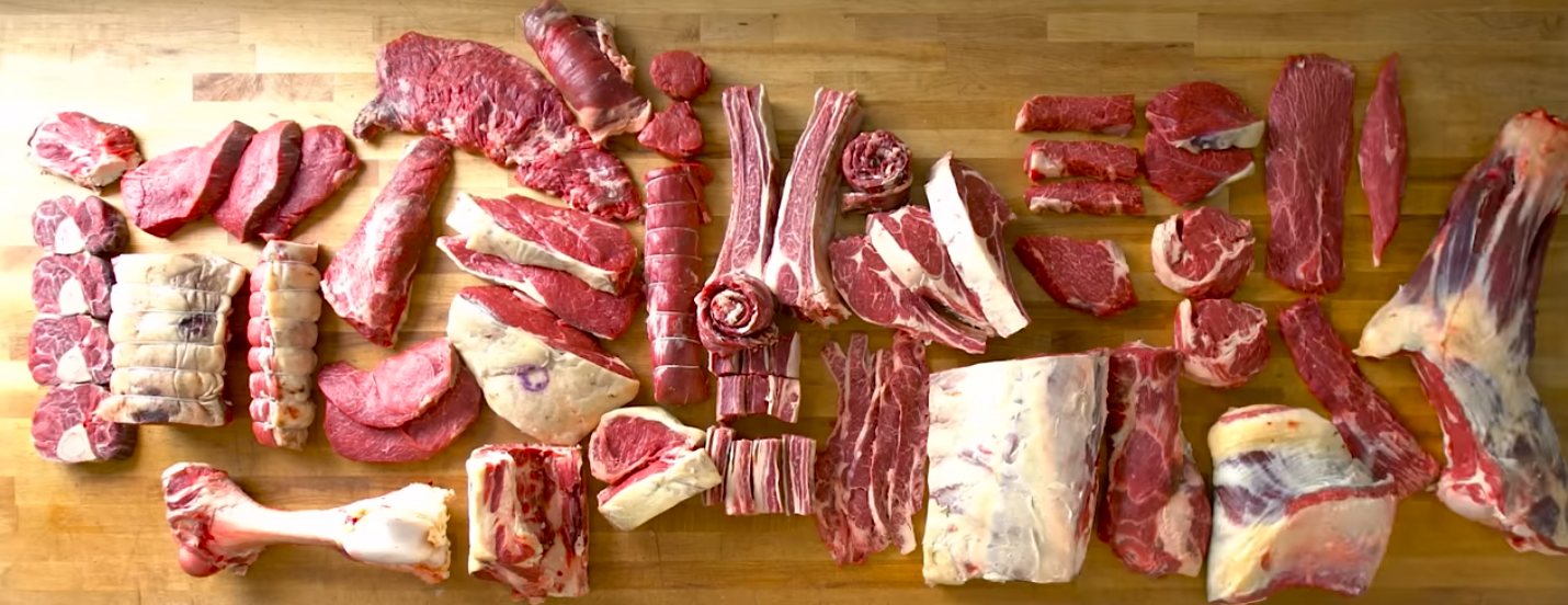Butchered grass fed beef on a wooden butcher table.