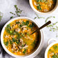 A delicious looking bowl of soup made from pork broth with kale, mushrooms, carrots, rice and pork breakfast sausage