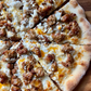Perfectly baked handcrafted pizza with Italian flavored pork sausage, goat cheese, and olive oil